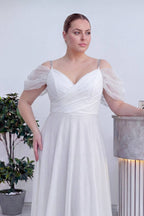 The ZKS beyaz kruvaze abiye elbise, şeffaf tül kolları ve omuzlardaki parlak taş detayları