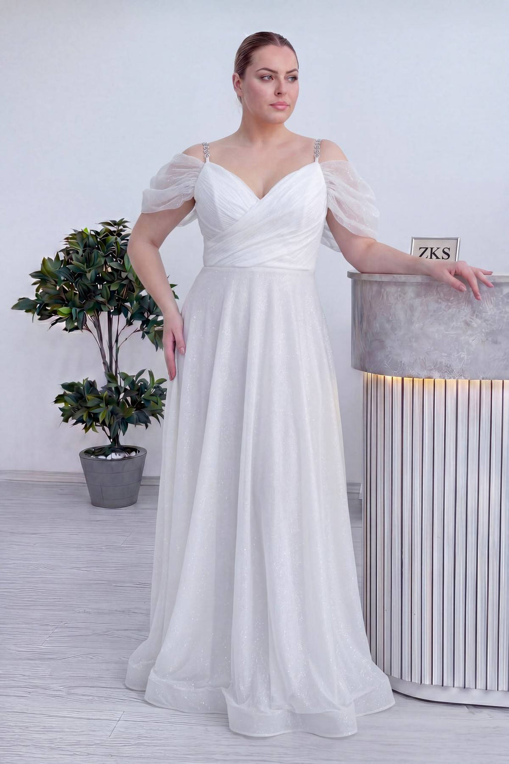 The ZKS beyaz kruvaze büyük beden abiye elbise, belden oturtmalı ve kloş etekli, parlak kumaş dokusu