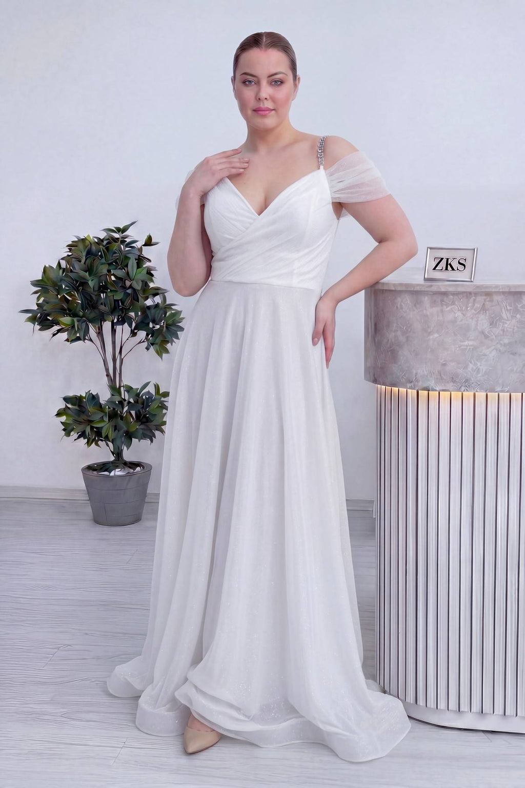 The ZKS beyaz kruvaze abiye elbise, ön görünümde drapeli göğüs kısmı ve parlak, dökümlü etek