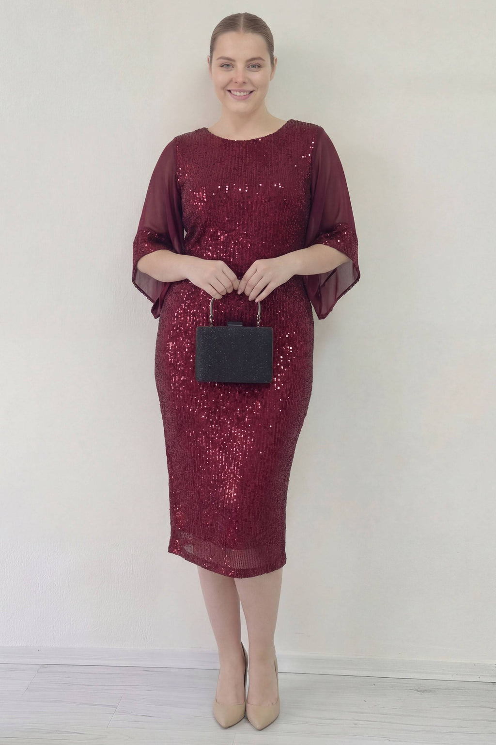 Bordo pulpayetli midi elbise, ZKS büyük beden, şeffaf kollu, elde siyah çanta ile tam boy görünüm