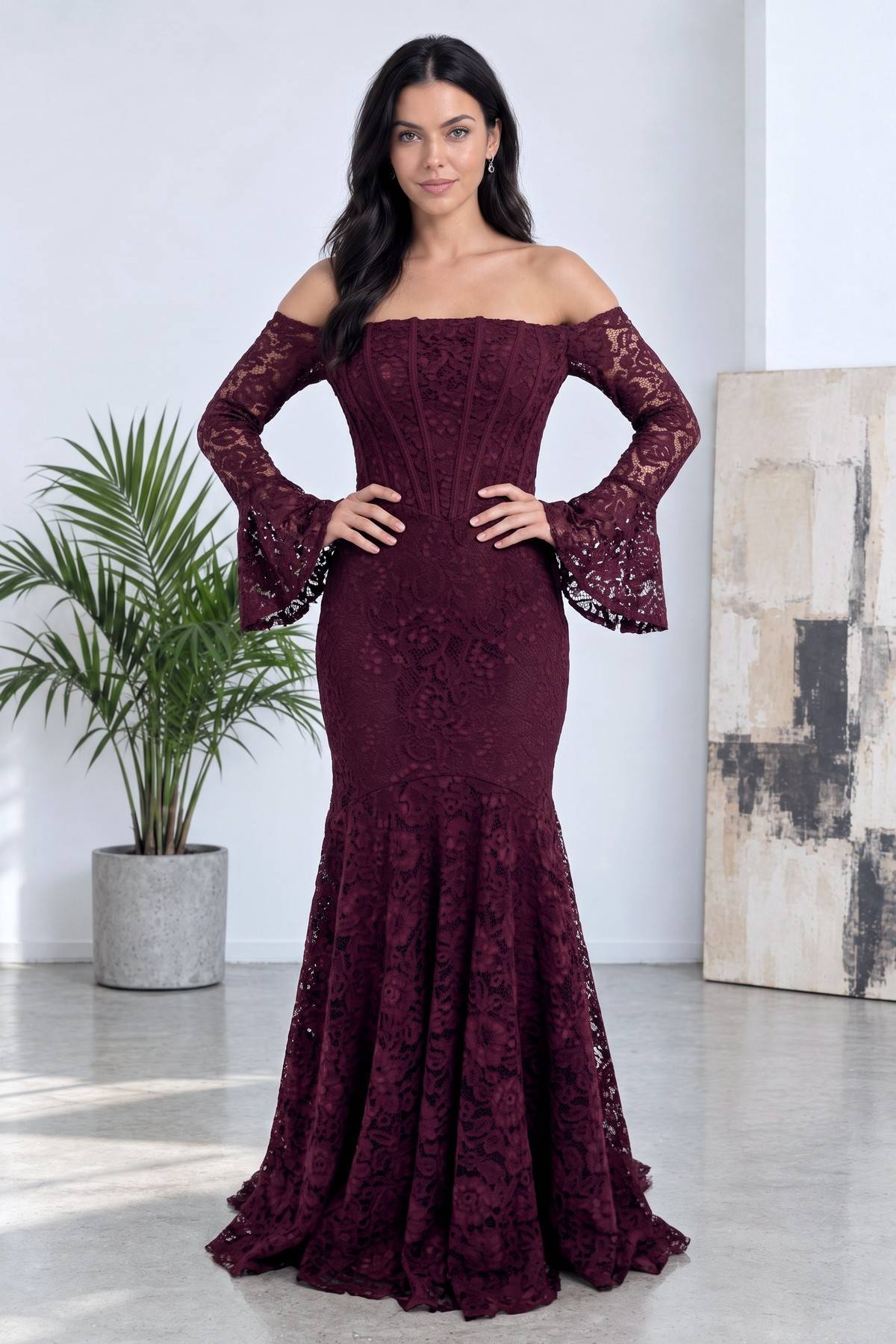 Modelin elleri belinde durduğu, bordo dantel balık abiye elbisenin tam boy duruşu