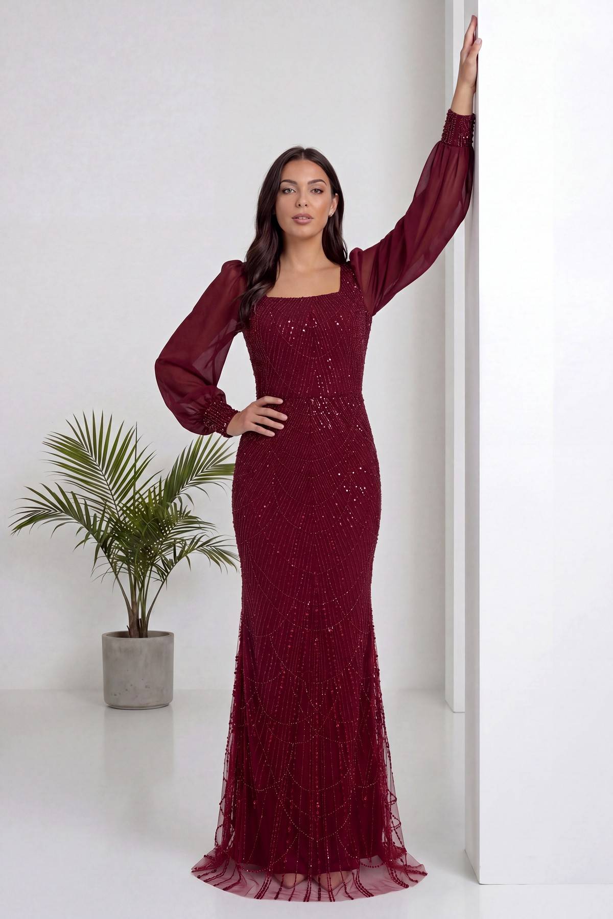 Bordo kare yaka şifon kollu balık kesim abiye elbise, duvara yaslanmış model, pullu detaylar