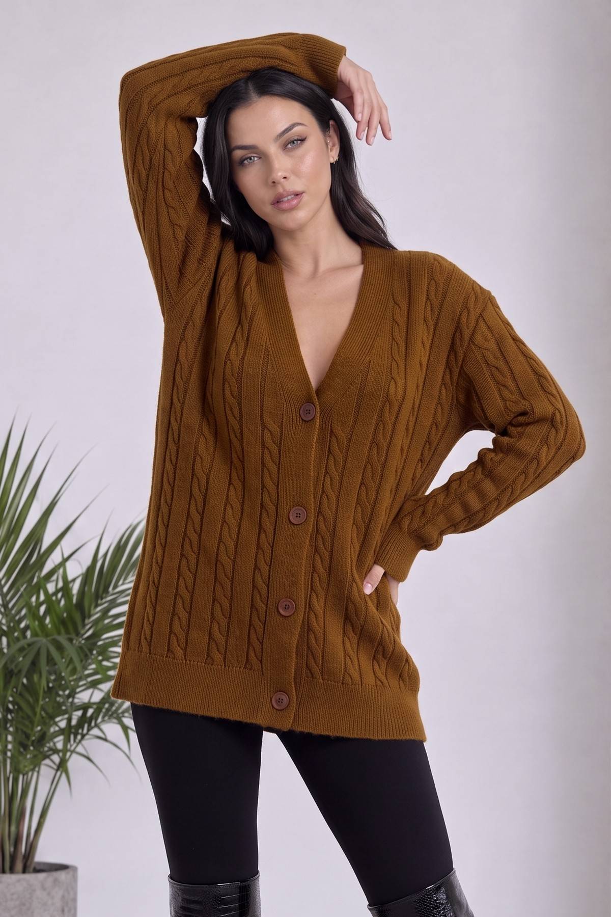 The ZKS camel rengi V yaka, örgü desenli, düğmeli triko hırka, modelin elini başının üzerine koyduğu poz