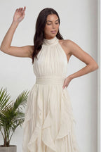 Ekru halter yaka abiye elbise, zarif boyunluk ve omuz detayları ön planda, hafifçe yana dönük