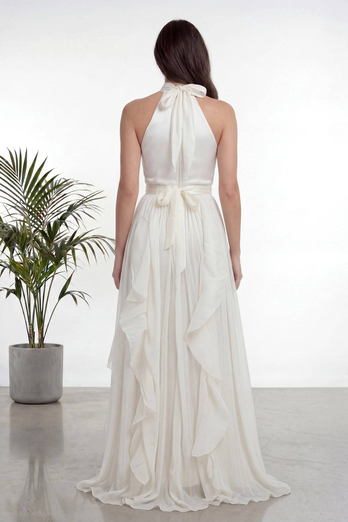 The ZKS ekru halter yaka fırfırlı uzun abiye elbise arka cepheden görünüm, boyun ve belde fiyonk bağlama detayı