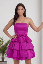 Fuşya straplez elbisenin üst kısmı ve belindeki fiyonk detayı yakın çekimde gösteriliyor