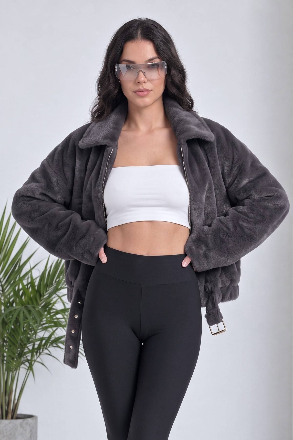 Gri The ZKS bomber ceket, beyaz crop top ve siyah tayt ile kombinlenmiş, modelin elleri belinde