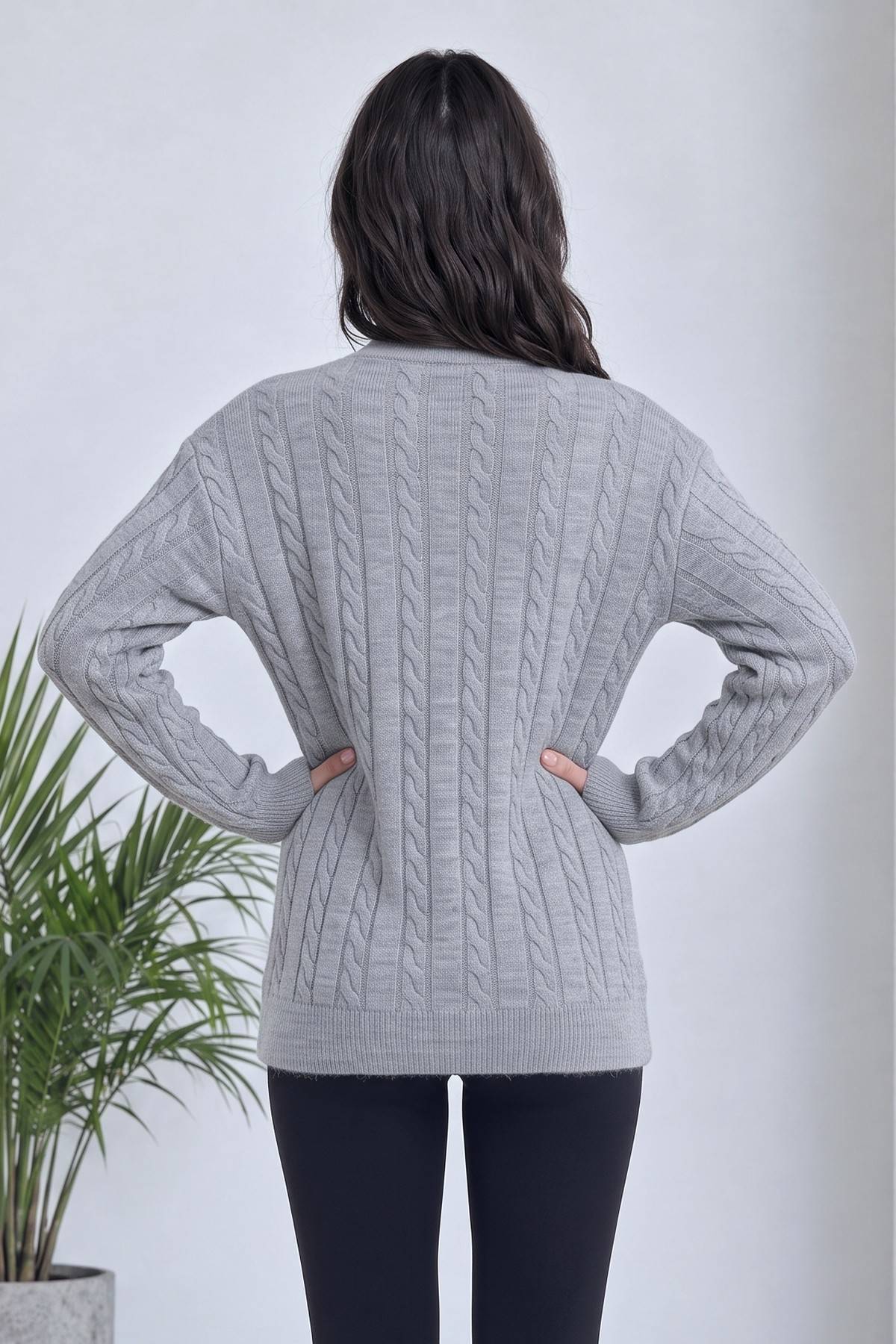 The ZKS gri V yaka triko hırka, kabartmalı örgü desenli, arka görünüm, modelin elleri belinde