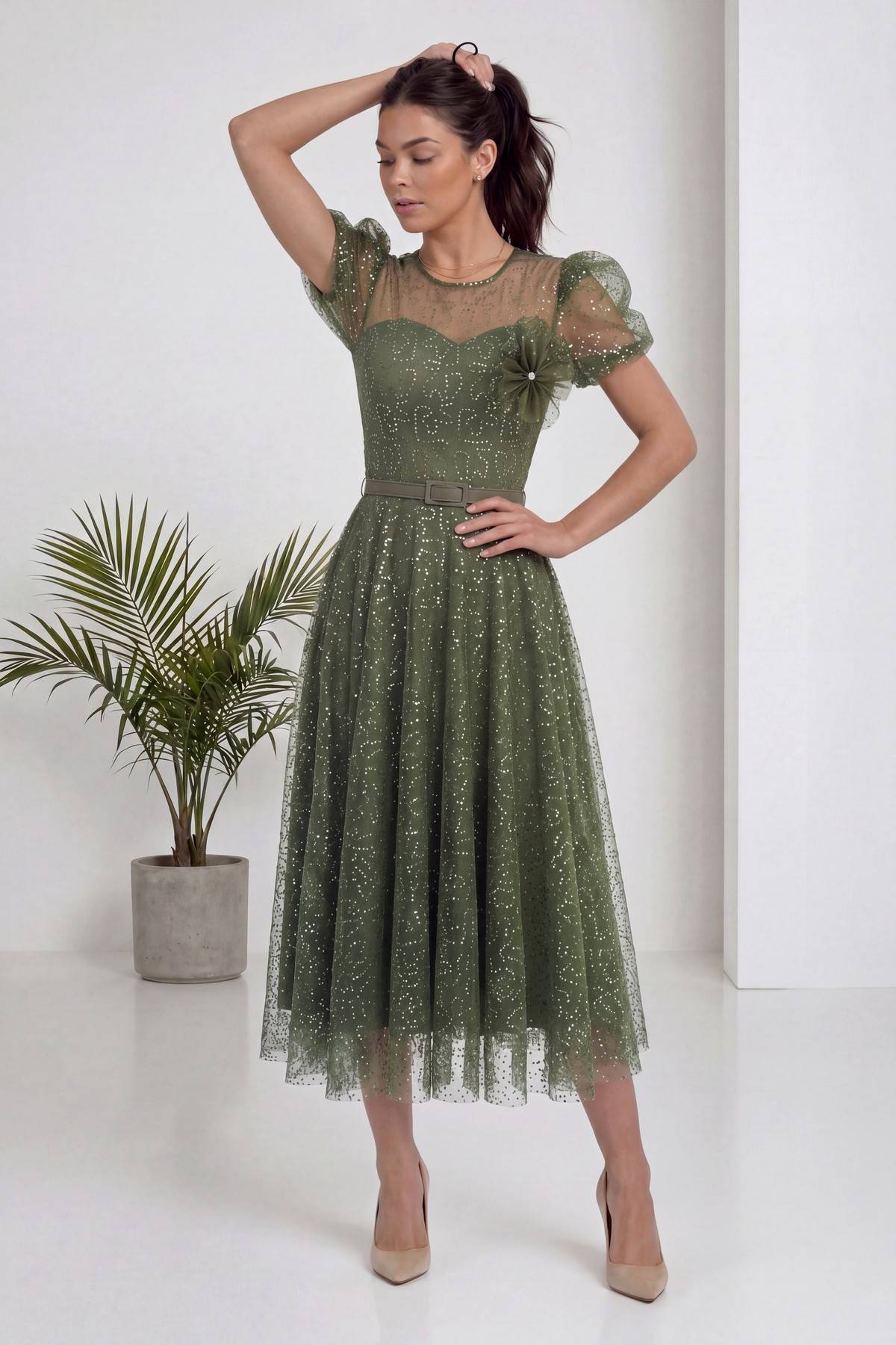 The ZKS haki balon kol abiye elbise, modelin elini saçına götürdüğü poz