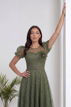 Haki dantel abiye elbise, The ZKS tasarımı, yan duruş, zarif aksesuar kullanımı