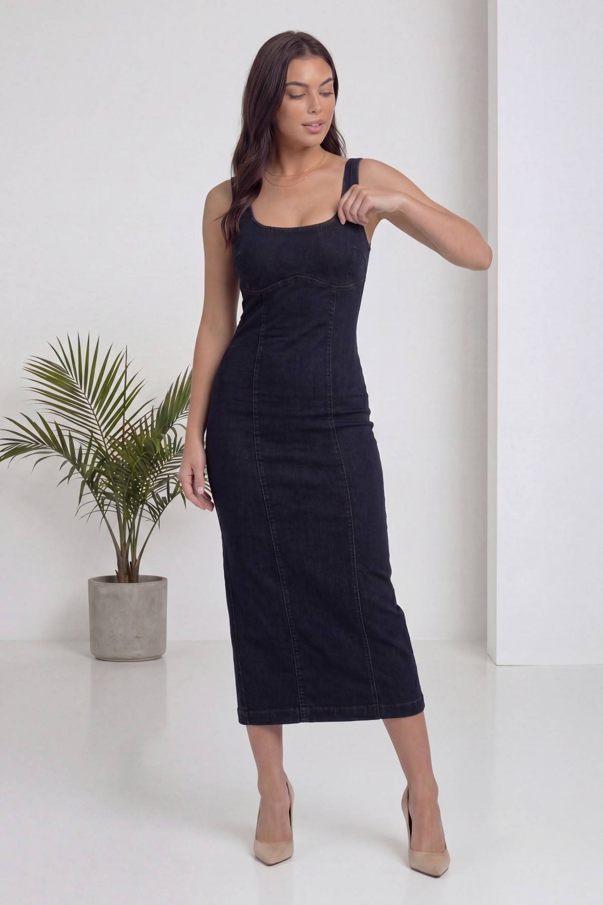 Modelin elbisenin askısını düzelttiği, lacivert kare yaka askılı kot midi elbise ön cepheden görünüm