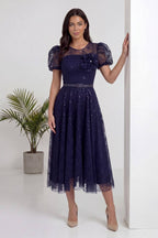 The ZKS lacivert midi abiye elbise, şeffaf kolları ve parıltılı dantel etek detayıyla yan görünüm.