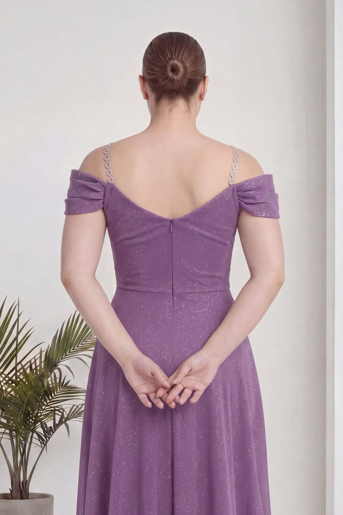 Büyük beden lila kruvaze abiye elbisenin arkadan görünümü, omuzları açık, V yaka, zincir askı detayı