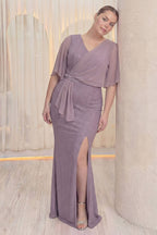 Model The ZKS lila abiye elbiseyi, yan taş detayları ve şifon koluyla sergiliyor, hafif yana eğimli duruş