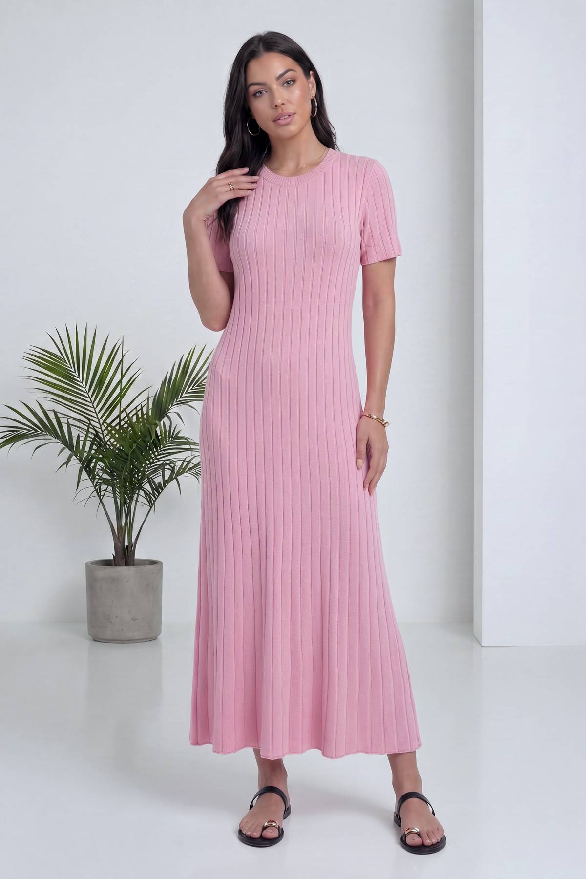 Pembe, bisiklet yaka, kısa kollu, fitilli triko midi elbise, modelin elini saçına götürdüğü poz