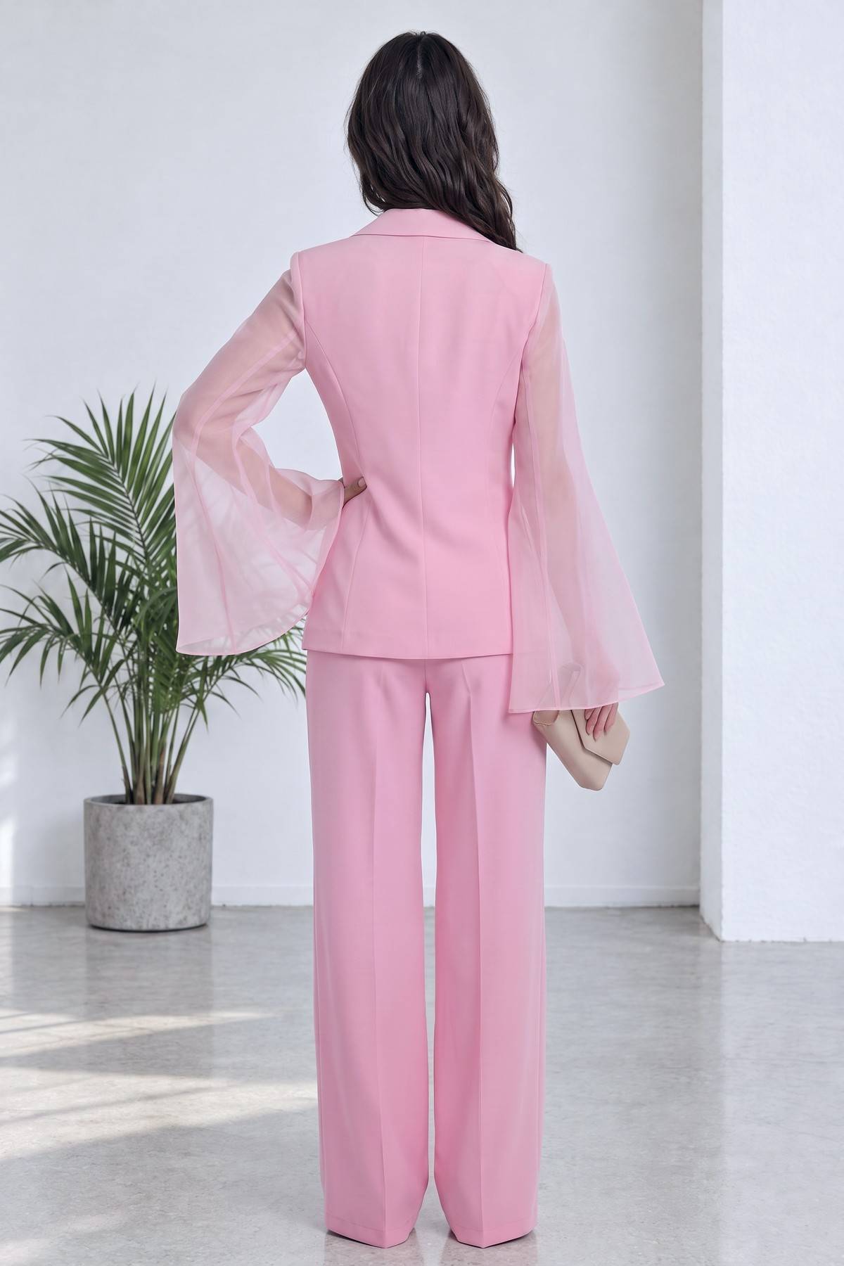 Pembe şifon kollu kruvaze ceket ve düz paça pantolon takımı, modelin arka görünümü