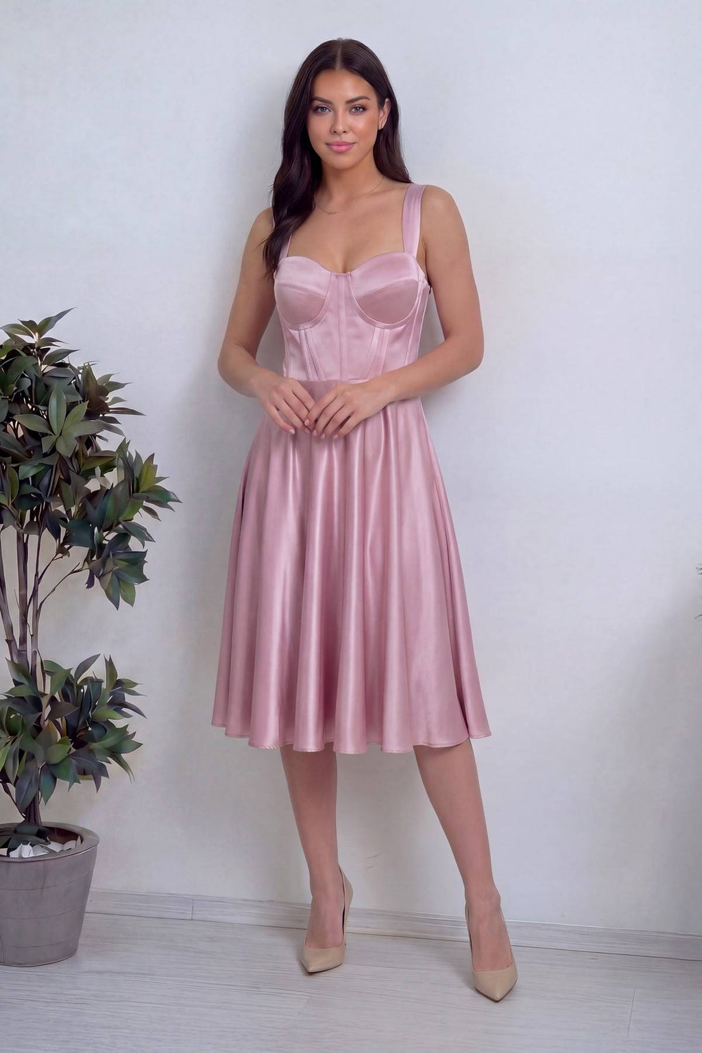 Pembe saten The ZKS elbise, korsajlı üst kısmı ve midi boy A kesim etekli, eller belde duruş