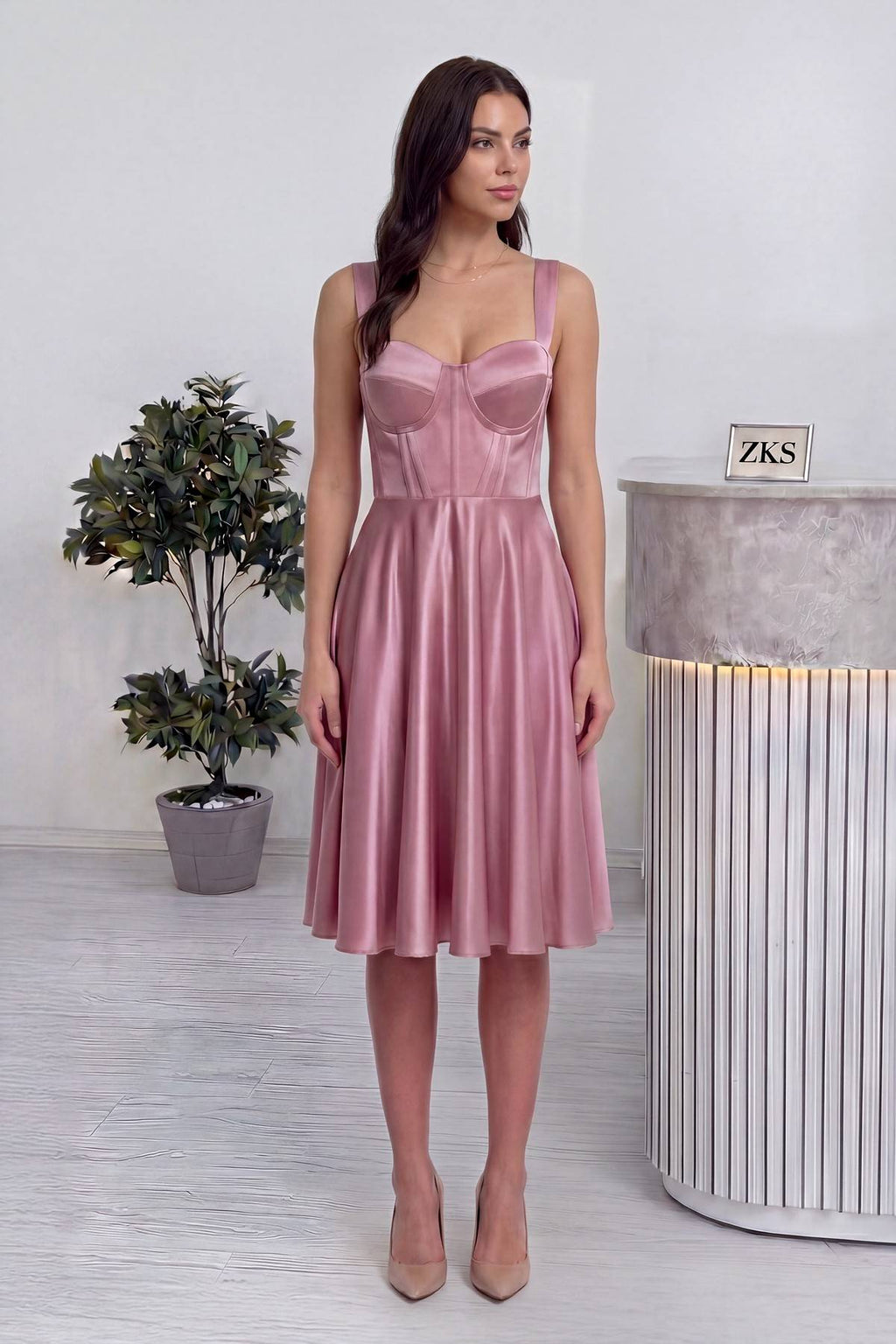 The ZKS pembe saten midi boy elbise, korsajlı ve askılı, tam ön duruş, zarif duruş