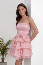 Pudra straplez elbise, fırfırlı etek ve beldeki fiyonk detayıyla yakın çekim