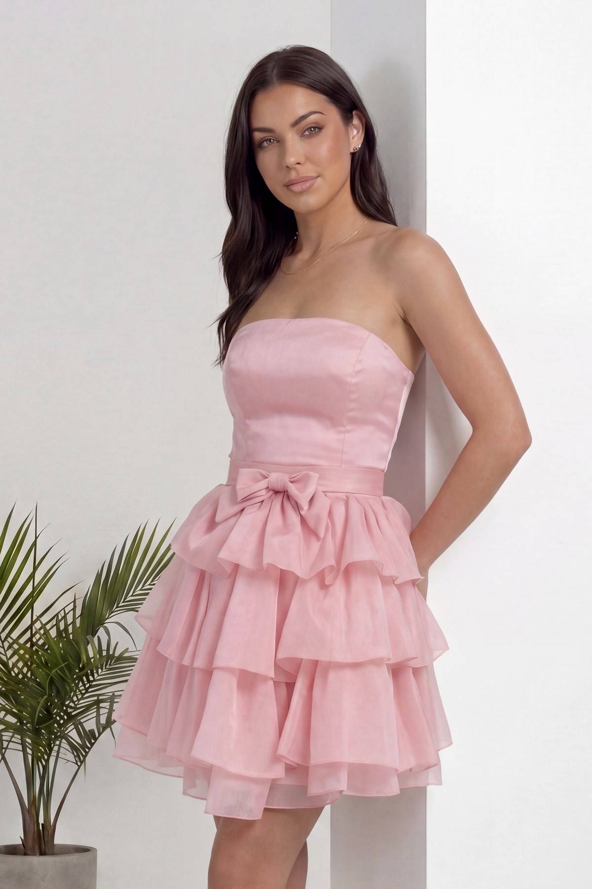 Pudra straplez elbise, fırfırlı etek ve beldeki fiyonk detayıyla yakın çekim