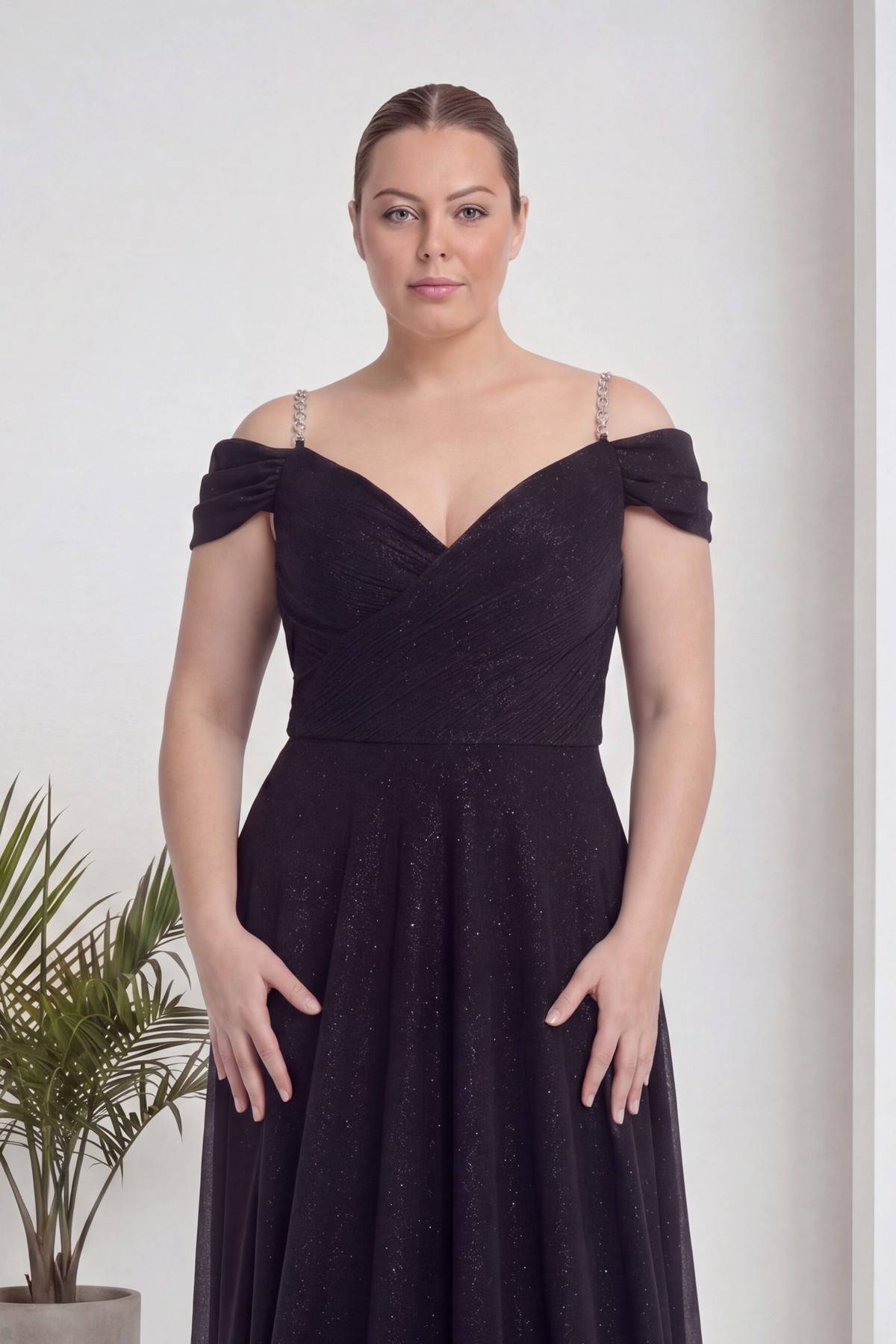 Büyük beden modelin yüzüne odaklanılmış, The ZKS siyah abiye elbise, V yaka, omuzları açık