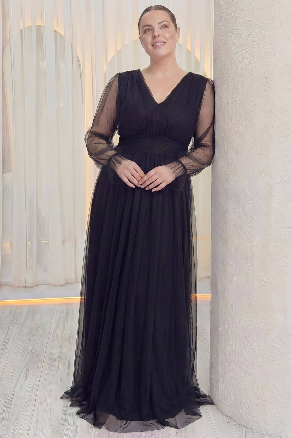 ZKS büyük beden siyah tül abiye elbise, duvara yaslanmış, V yaka, beli vurgulayan kemer