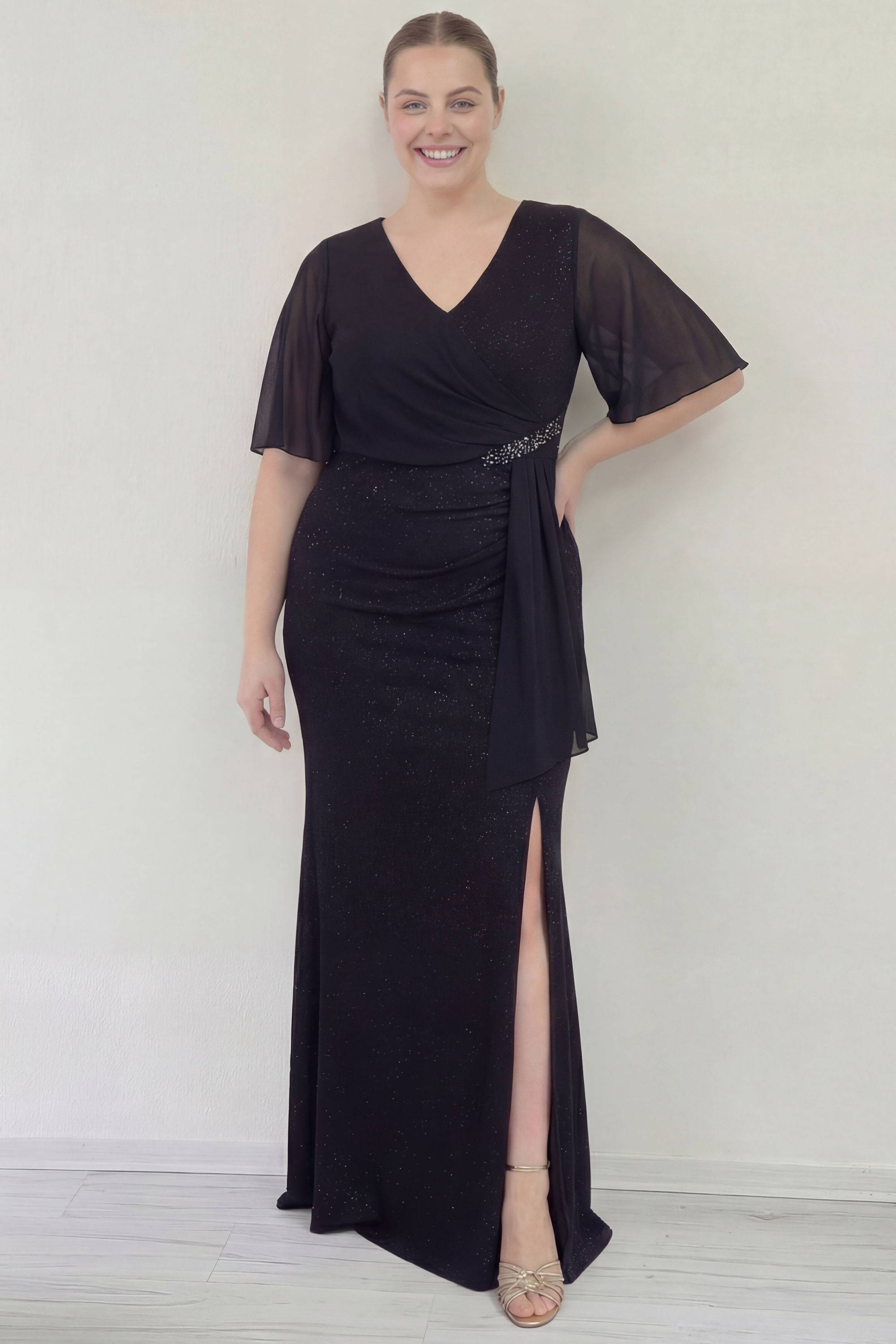 Büyük beden siyah şifon abiye elbise, V yaka, yan taşlı kemer, yırtmaçlı, modelin duruşu