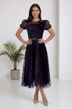 The ZKS siyah dantel midi abiye elbise, balon kol ve çiçek aksesuarı detaylı ön görünüm