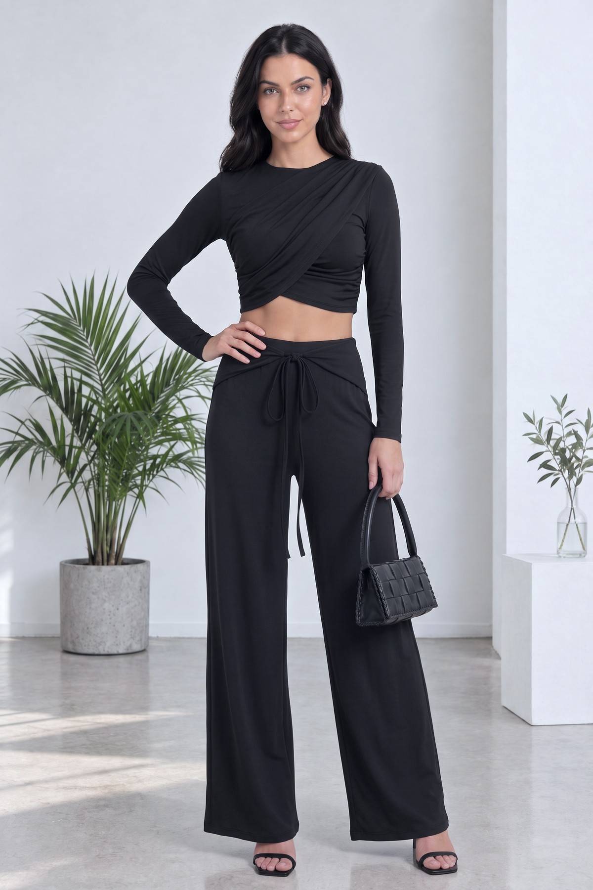 The ZKS siyah crop bluz ve geniş paça pantolon takımı elinde çanta ile tam duruş pozu ikinci açı
