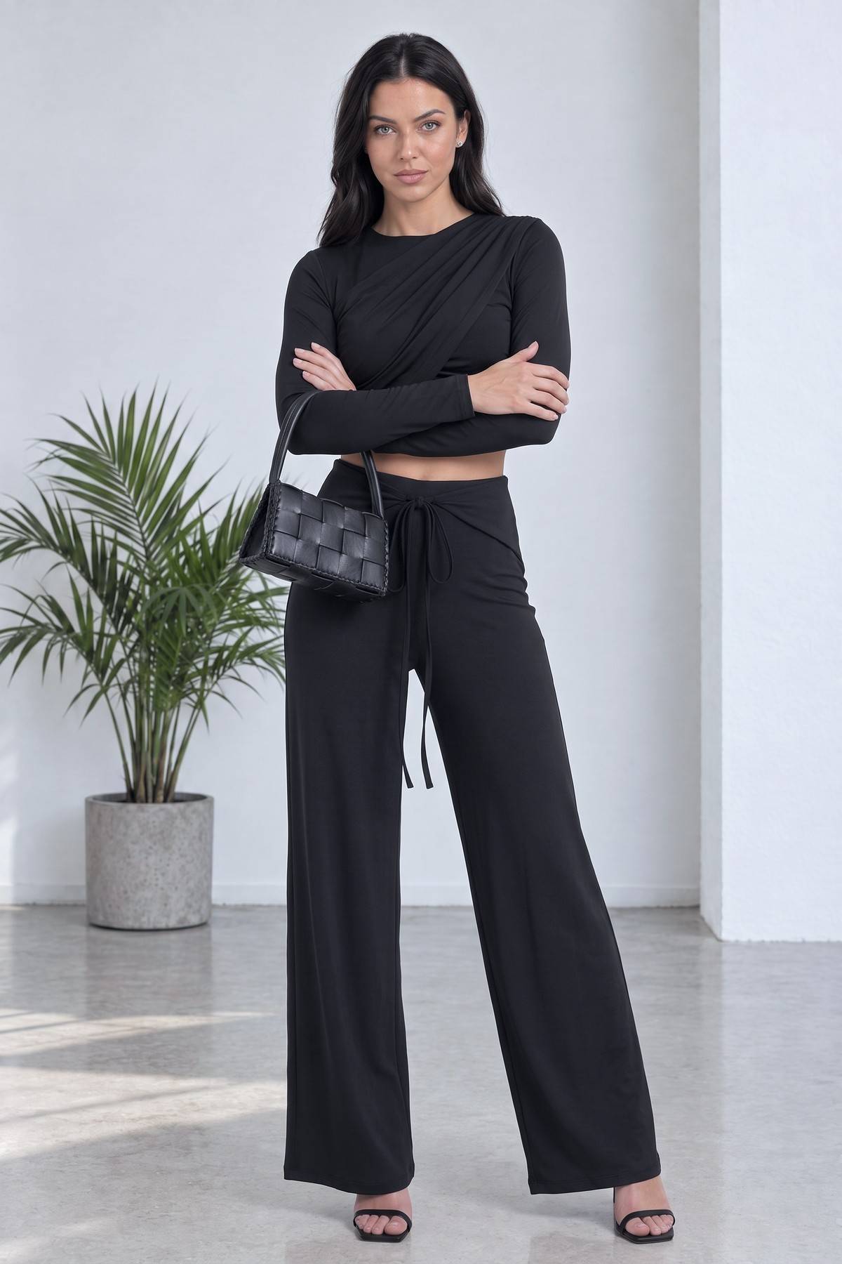 The ZKS siyah crop bluz ve geniş paça pantolon takımı kollarını kavuşturmuş duruş pozu