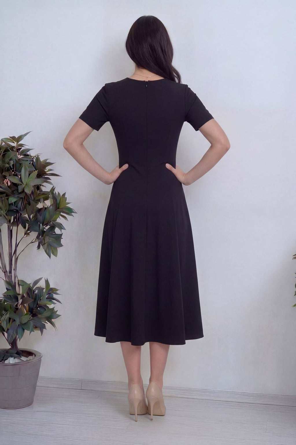 Arkadan eli belinde, siyah kısa kol pileli midi boy günlük elbise