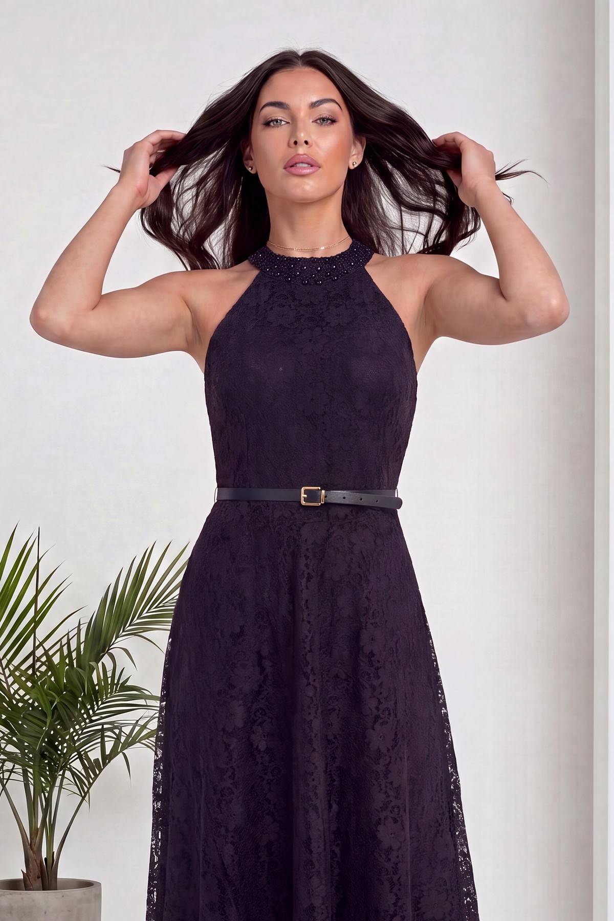 The ZKS siyah dantel abiye elbise halter yaka, inci detaylı yaka, kemerli, model saçlarıyla oynuyor