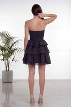 Altı farklı model, The ZKS straplez siyah fırfır etekli kısa abiye elbiseyi farklı mekanlarda giymiş, elbisenin genel görünümünü sergiliyor.