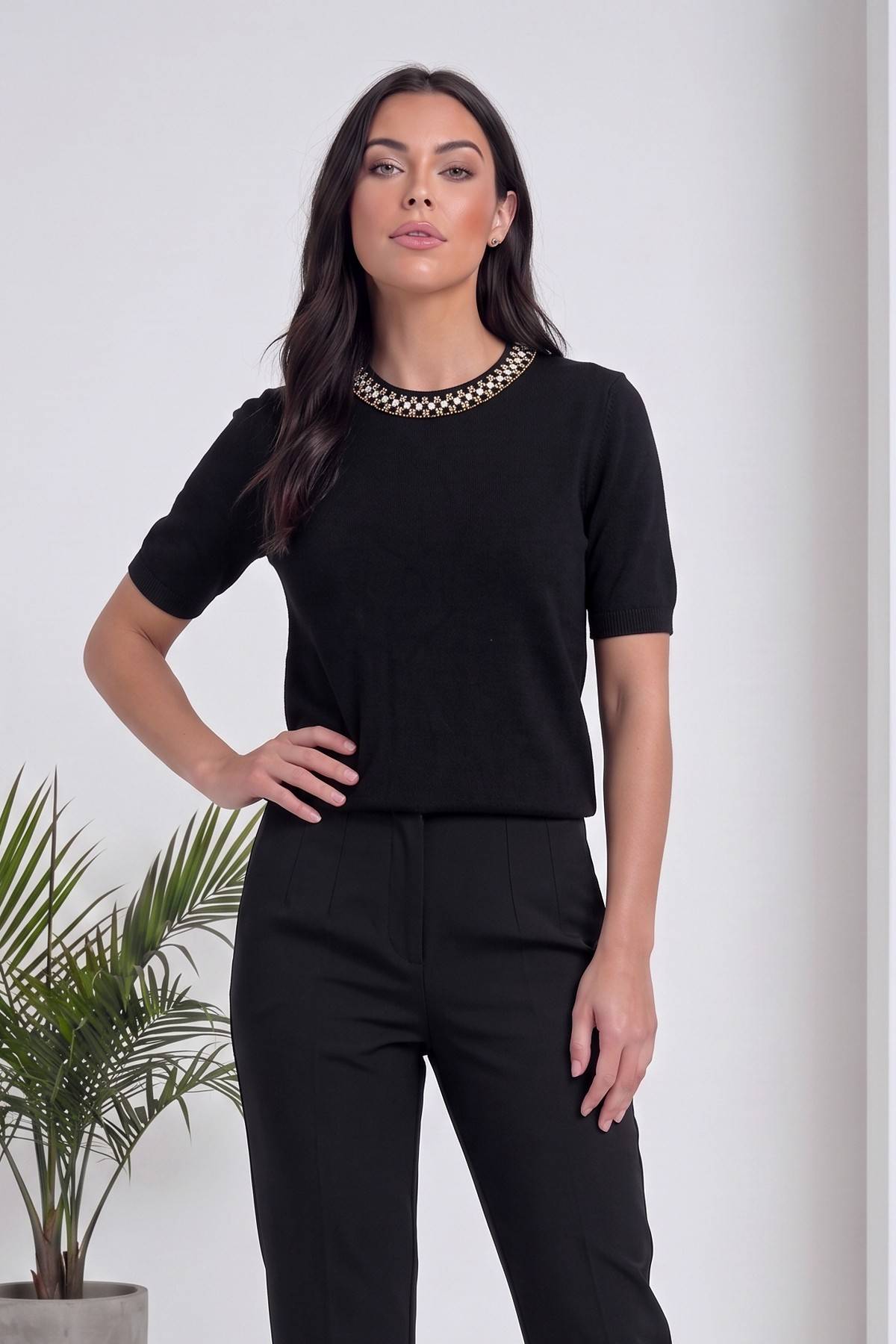 The ZKS siyah triko, inci yaka detayı, modelin eli belinde duruyor