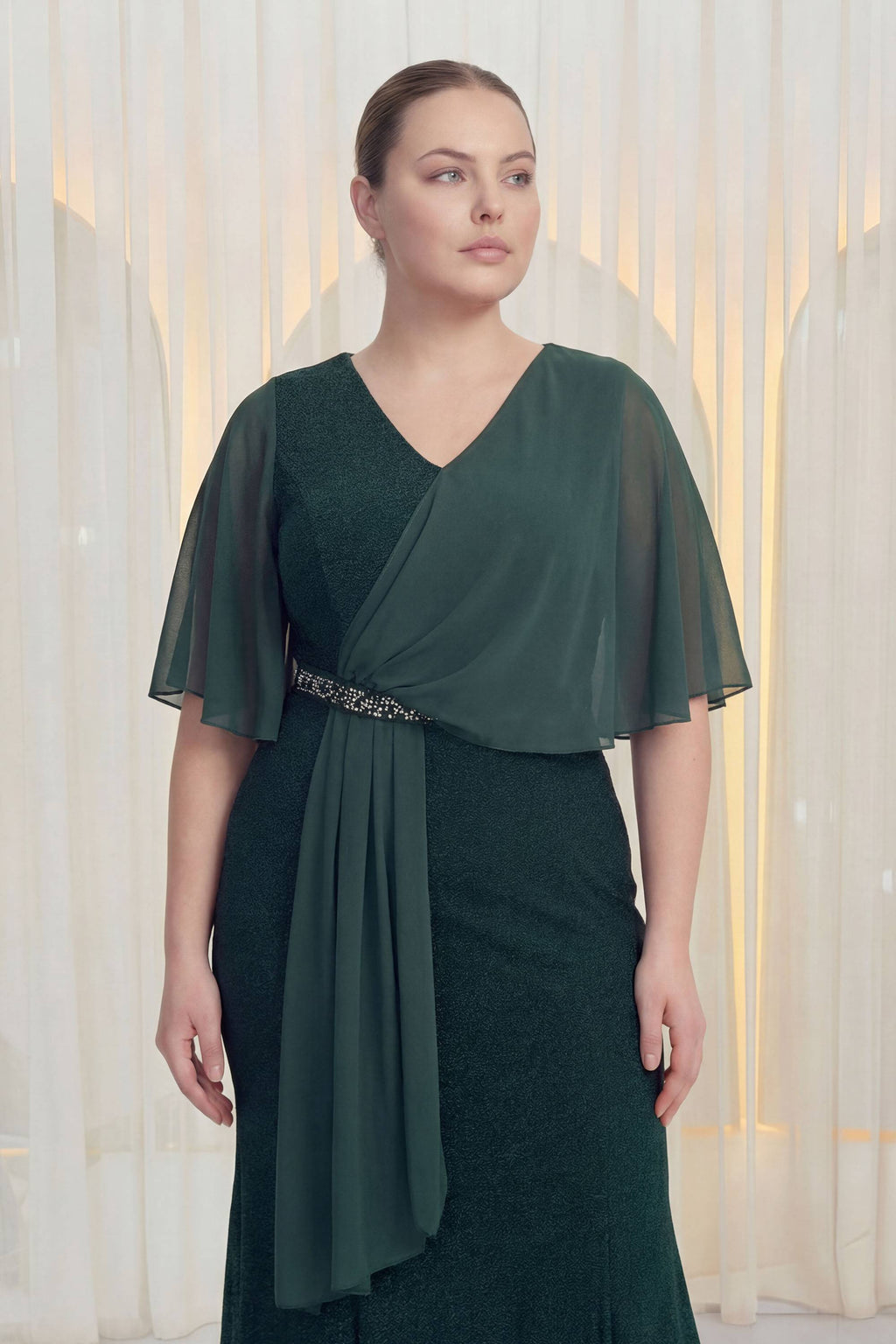 The ZKS büyük beden şifon kol abiye elbise, zümrüt yeşili, yandan görünüm, V yaka ve taşlı kemer detayı