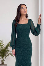 The ZKS yeşil kare yaka şifon abiye, duvara yaslanmış, zarif duruşu ve işlemeleri sergiliyor